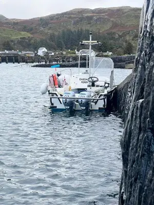 a small boat is docked in the water at Easdale Cottage in Ellanbeich
