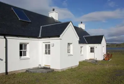 a white house with a black roof at Easdale Cottage in Ellanbeich