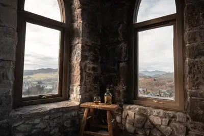 a table in a stone room with two windows at The Church Tower in Crieff