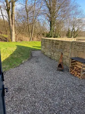 a stone wall and a bench and a table at Peaceful Shepherd’s Hut in beautiful countryside. in Linlithgow