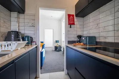 a kitchen with blue cabinets and a counter top at Bella House - 3 bed house in Glasgow in Glasgow