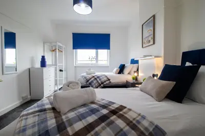 a bedroom with two beds with blue blinds at Bella House - 3 bed house in Glasgow in Glasgow