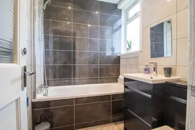 a bathroom with a bath tub and a sink at Bella House - 3 bed house in Glasgow in Glasgow
