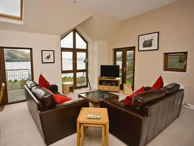 a living room with two leather couches and a television at The Quaich in Stron-fearnan