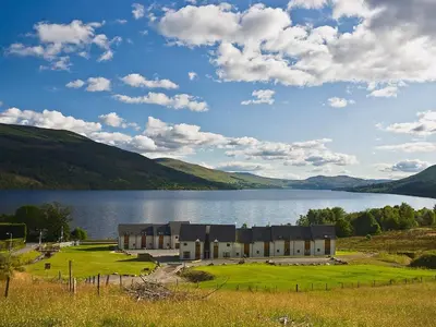 a building next to a large body of water at The Quaich in Stron-fearnan