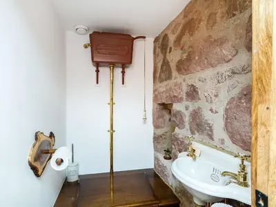 a bathroom with a stone wall and a sink at Knock Old Castle in Largs