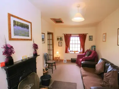 a living room with a couch and a fireplace at The Smithy - Uk38001 in Kirkcowan