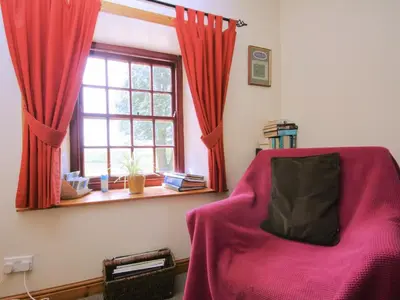 a bedroom with a red bed and a window at The Smithy - Uk38001 in Kirkcowan