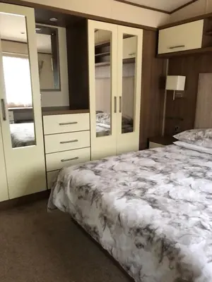 a bedroom with a large bed and some cabinets at River View 46 in Dunoon