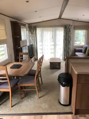 a dining room and living room with a table and chairs at River View 46 in Dunoon