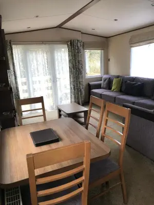 a living room with a table and chairs and a couch at River View 46 in Dunoon