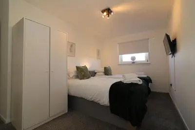a bedroom with a large bed and a window at Signature - Honeywell House in Chapelhall