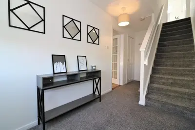 a hallway of a home with stairs and a table at Signature - Honeywell House in Chapelhall
