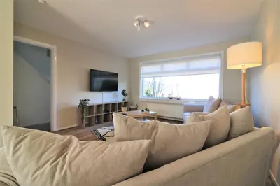 a living room with a couch and a large window at Signature - Honeywell House in Chapelhall
