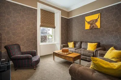 a living room with a couch and a chair and a table at Annfield House, Callander in Callander