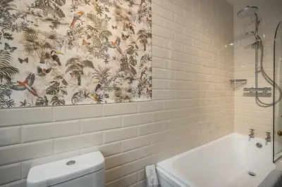 a bathroom with a shower and a tub and a toilet at Annfield House, Callander in Callander