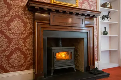 a fireplace with a fire in it in a room at Annfield House, Callander in Callander