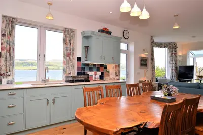 a kitchen and dining room with a wooden table at The Neuk in Tighnabruaich