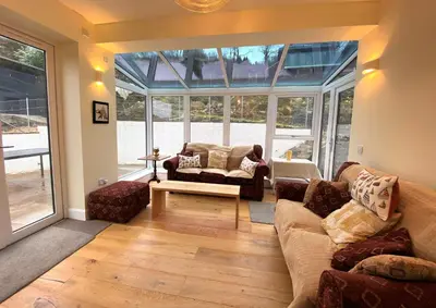a living room filled with furniture and a large window at The Neuk in Tighnabruaich