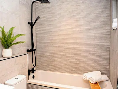 a bathroom with a shower with a tub and a toilet at Forget Me Not Cottage in Culross