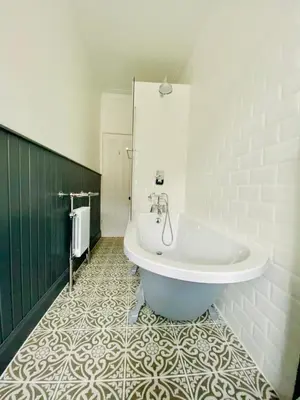 a bathroom with a tub and a tiled floor at Upper Villa, Tighnabruiach, Argyll & Bute in Tighnabruaich