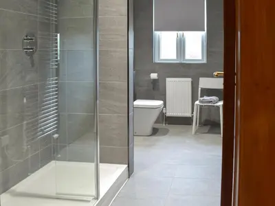a bathroom with a toilet and a glass shower at The Lodge in Linlithgow