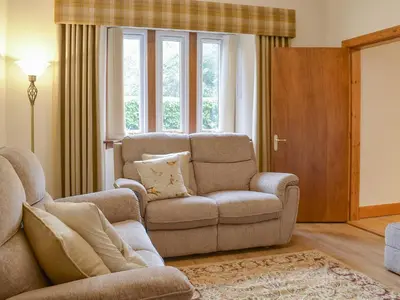 a living room with a couch and a chair at The Lodge in Linlithgow