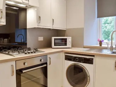 a kitchen with a washing machine and a microwave at The Lodge in Linlithgow