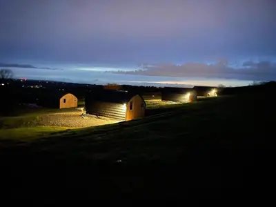 a group of barns in a field at night at Fox's Den in Bathgate