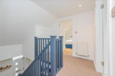 a hallway with a blue staircase in a house at 5 Bed cottage with Hot tub in Bannockburn