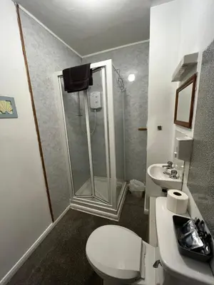 a bathroom with a shower and a toilet and a sink at Dunarle Guesthouse in Oban