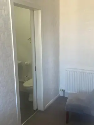 a bathroom with a toilet and a door open at Dunarle Guesthouse in Oban