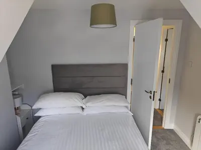 a bed with white sheets and pillows in a bedroom at Station View in Oban