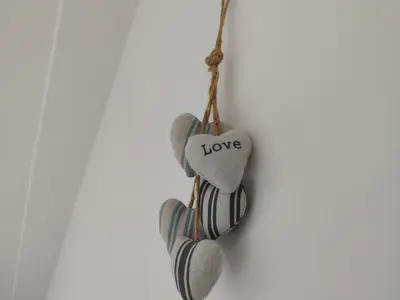 a heart ornament with the word love hanging on a wall at Station View in Oban