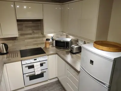 a kitchen with white cabinets and a white refrigerator at Station View in Oban