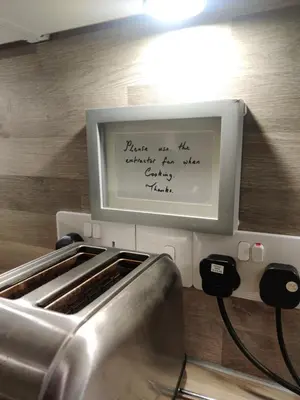 a sign on a counter in a kitchen with a sink at Station View in Oban