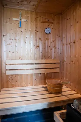 a sauna with a clock on a wooden wall at Jura, Mrs Leonard's Cottage in Isle of Jura