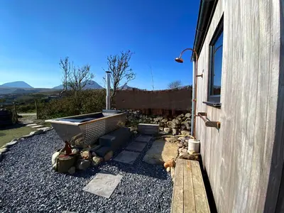 a backyard with a rock garden next to a building at Jura, Mrs Leonard's Cottage in Isle of Jura