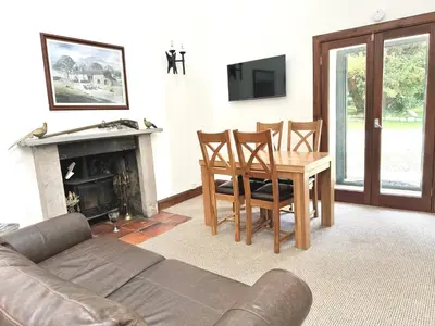 a living room with a couch and a table and a fireplace at The Bothy of Ballachulish House in Ballachulish