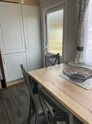 a dining room with a wooden table and chairs at Swift Bordeaux 67 in Dunoon