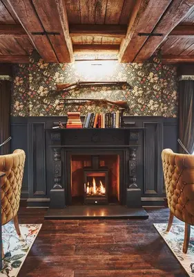 a fireplace in a living room with two chairs at No17 The Promenade in Oban