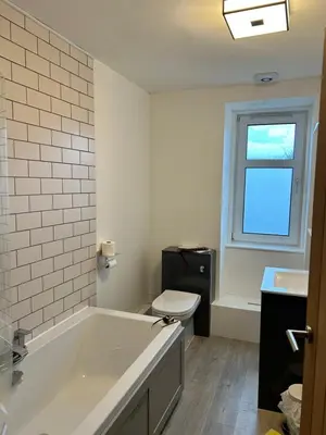 a bathroom with a tub and a toilet and a window at Lochaline Hotel in Lochaline