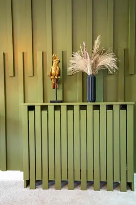 a green wall with a table with a vase at The Arran Suite - Your Stylish Scottish Getaway! in Glasgow