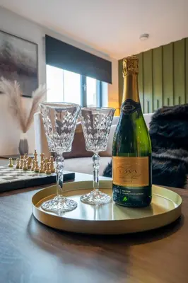 a bottle of champagne and two glasses on a tray at The Arran Suite - Your Stylish Scottish Getaway! in Glasgow