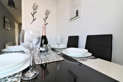 a table with glasses and plates and a bottle of wine at Signature - Whistleberry House in Hamilton