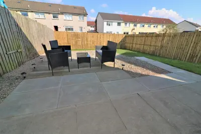 a patio with four chairs and a fence at Signature - Whistleberry House in Hamilton