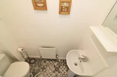 a small bathroom with a toilet and a sink at Signature - Whistleberry House in Hamilton