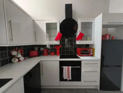 a kitchen with white cabinets and red mittens at Doocot At Bonnyside House - New Hot Tub Aug 2025 in Bonnybridge