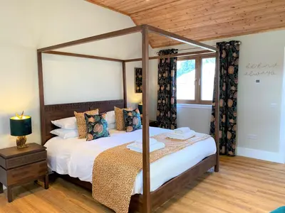 a bedroom with a canopy bed in a room at Partridge Lodge with Hot Tub in Forgandenny