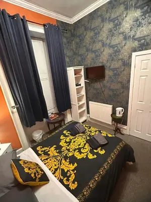 a bedroom with a bed with a black and yellow blanket at the CITY- Braveheart House in Edinburgh